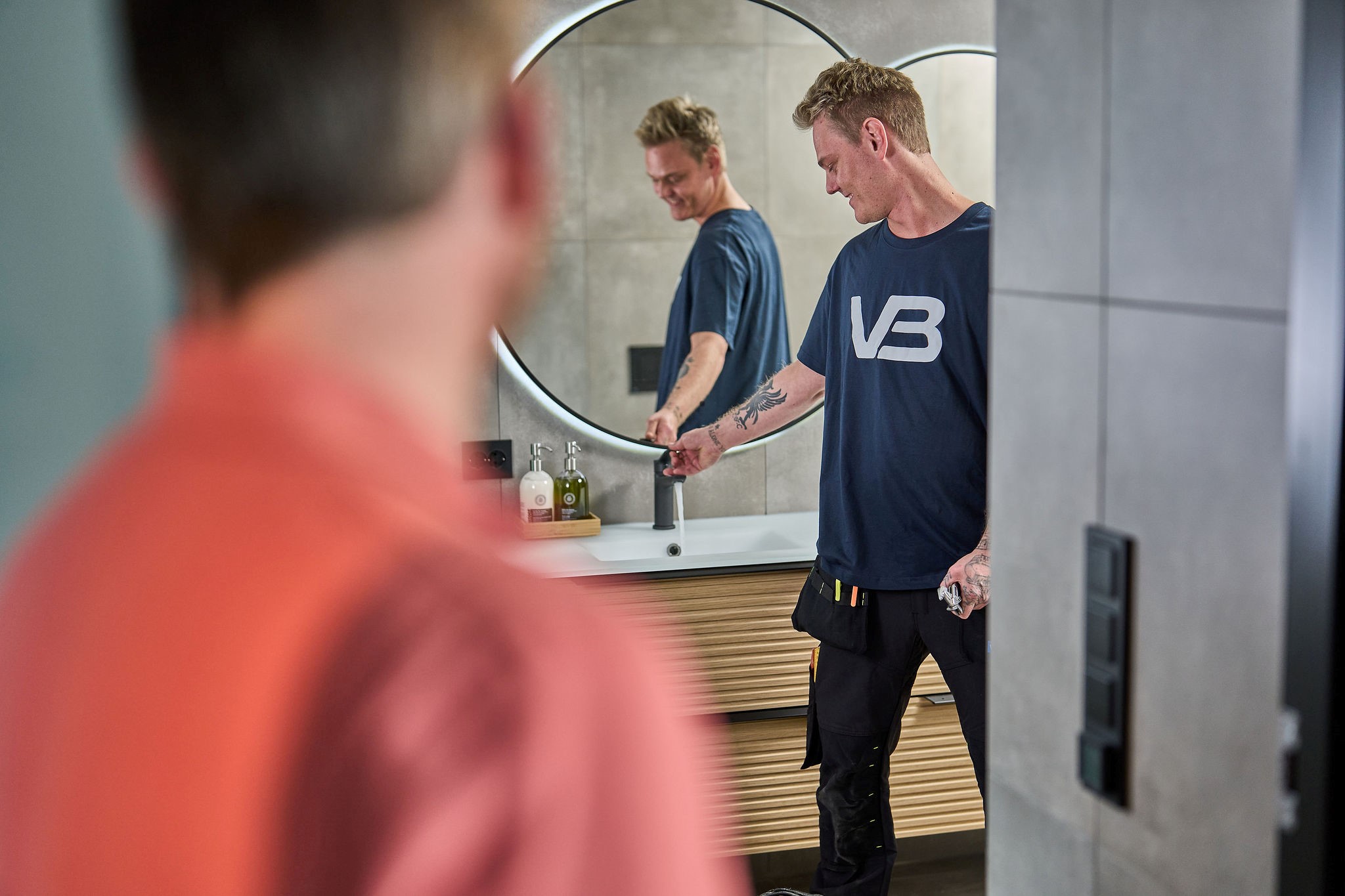 VB-rørlegger tester servantbatteriet etter at nytt baderomsmøbel er montert.